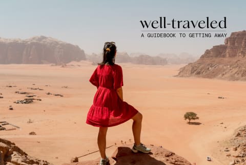 Woman in red dress looks out over the desert